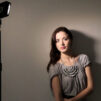 Girl standing near grey wall posing for photo with led lights