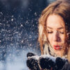 Girl blowing snow in the winter