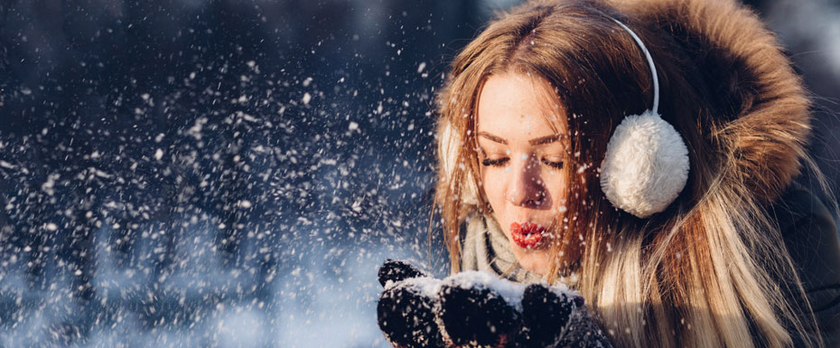 Girl blowing snow in the winter