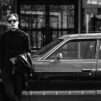 Man standin close to car Black and white