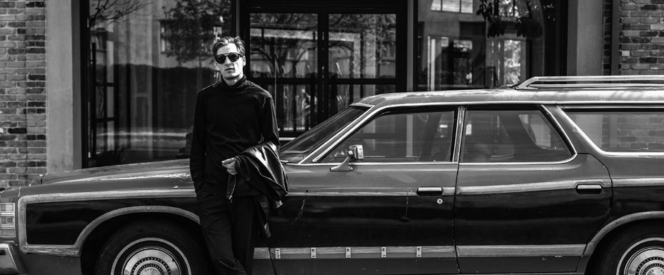 Man standin close to car Black and white