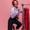 Slim Lady Fashionable Trousers Blouse Red Hat Is Sitting Chair Stand With Shiny Dresses