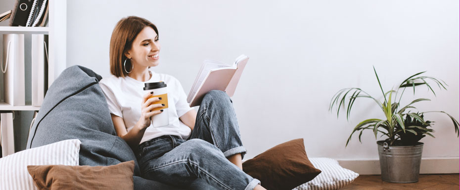 short-haired-girl-white-t-shirt-with-smile-reading-book-while-sitting-soft-bean-bag-2