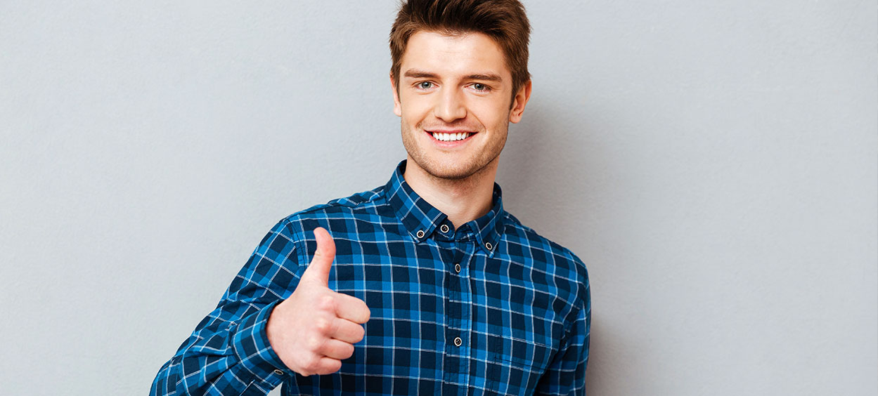 young-joyful-student-man-holding-thumb-up-isolated