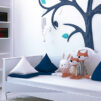 Bright Child's Bedroom with blue colored tree on the wall. Gracefully done decoration, soft toys placed on the couch