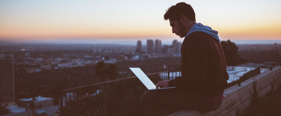 Freelancer sitting on the edge of the building working