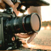 Guy Holding camera on the road during sunset