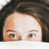 Woman sleeps over with blanket in the bed