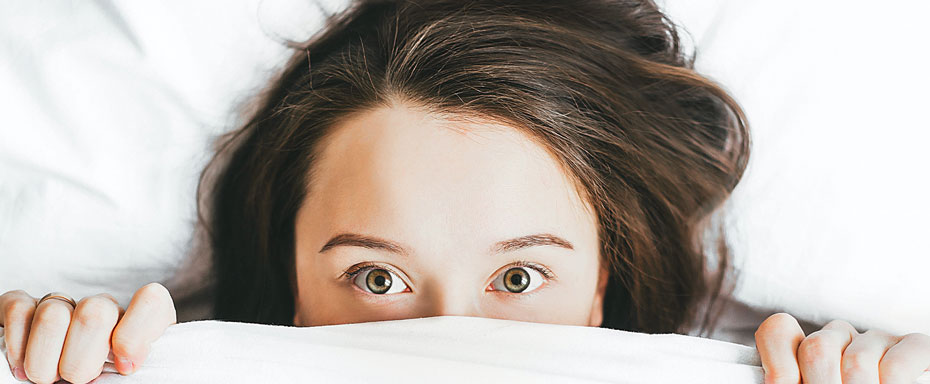 Woman sleeps over with blanket in the bed