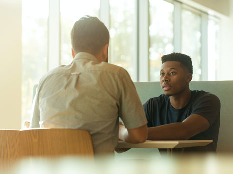 Man sitting around the desk speaking