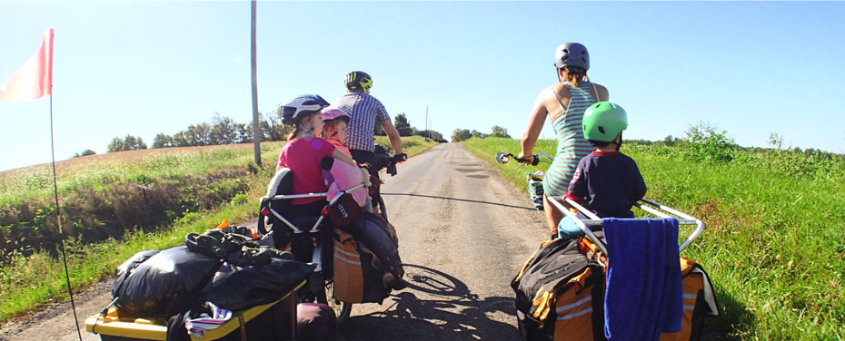 Kids with parents moving in the bike outside the city