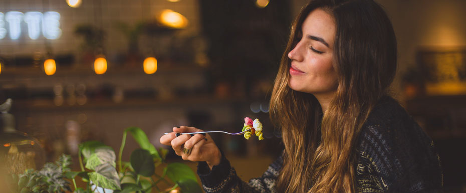 Woman holding fork in front table