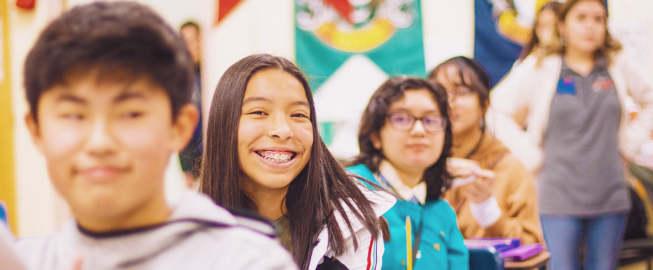 smiling woman in gray hoodie beside smiling boy in blue and red jacket